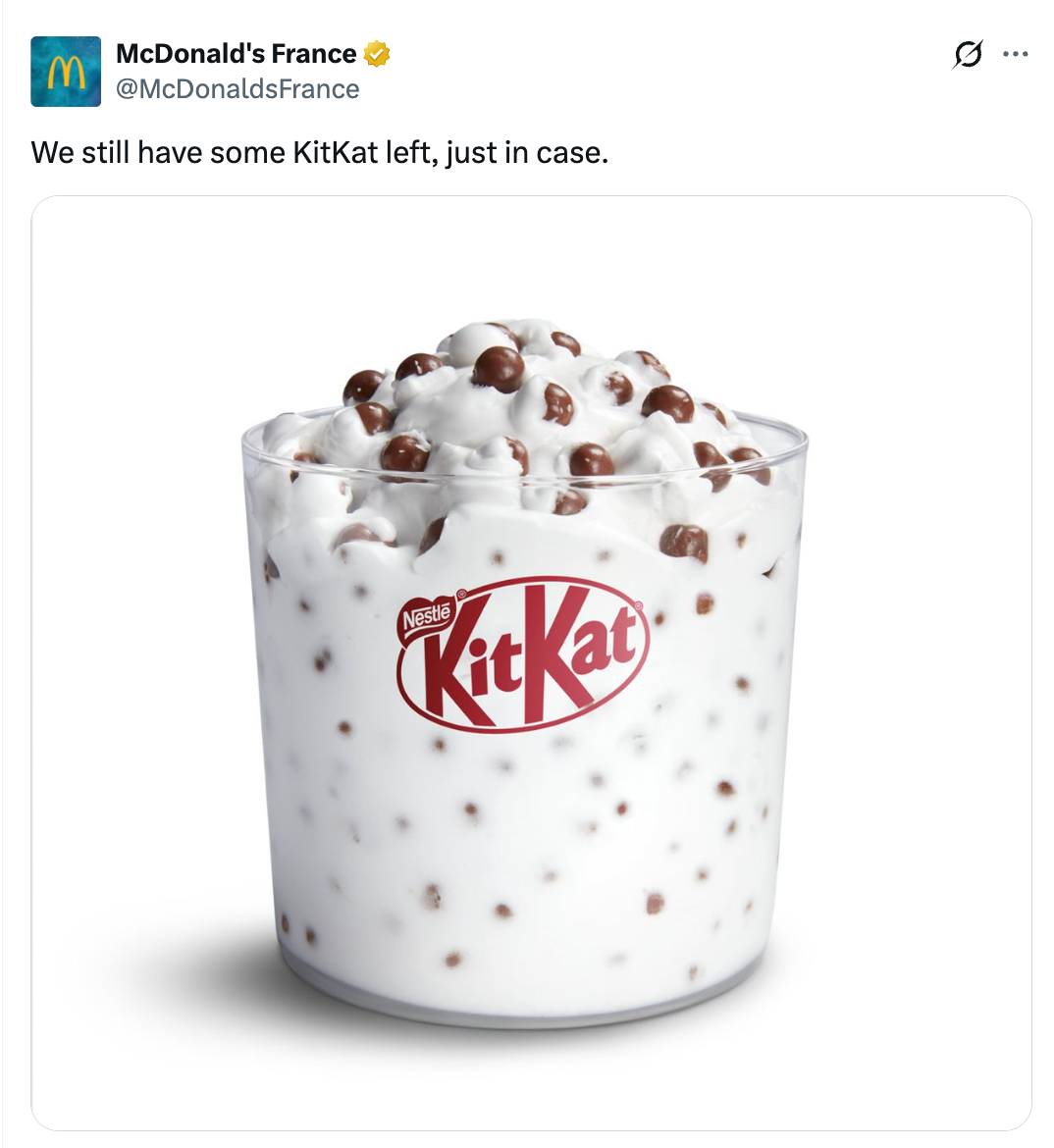 A McDonald's promotional representation features a McFlurry dessert with KitKat pieces, topped with cocoa pieces successful a wide cup
