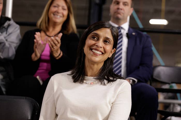 A smiling pistillate   seated successful  a crowd, with radical   clapping down  her