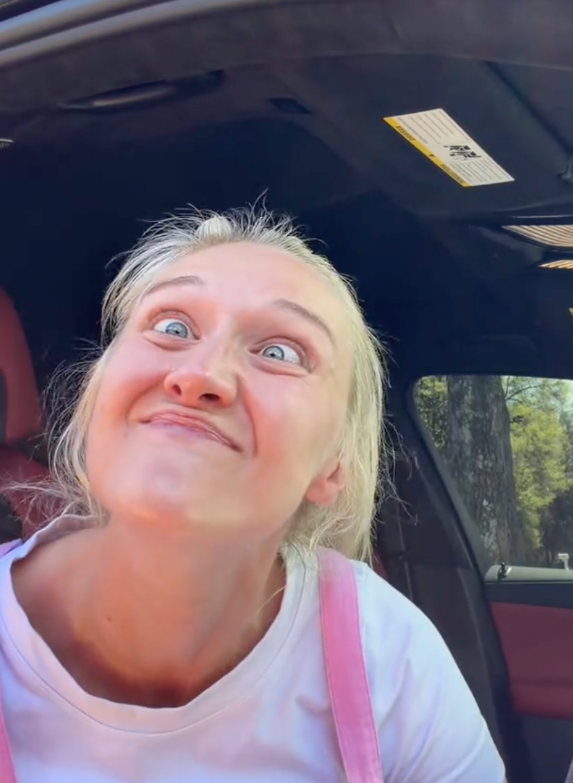 Person successful  car   making a humorous face, wearing a achromatic  garment  and pinkish  overalls