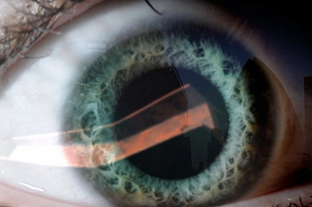Close-up of a human eye, showing intricate details of the iris and reflection on the surface