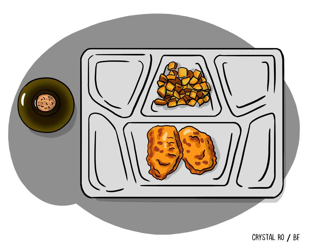 Lunch tray with two chicken nuggets, a portion of diced potatoes, and a small dish of sauce