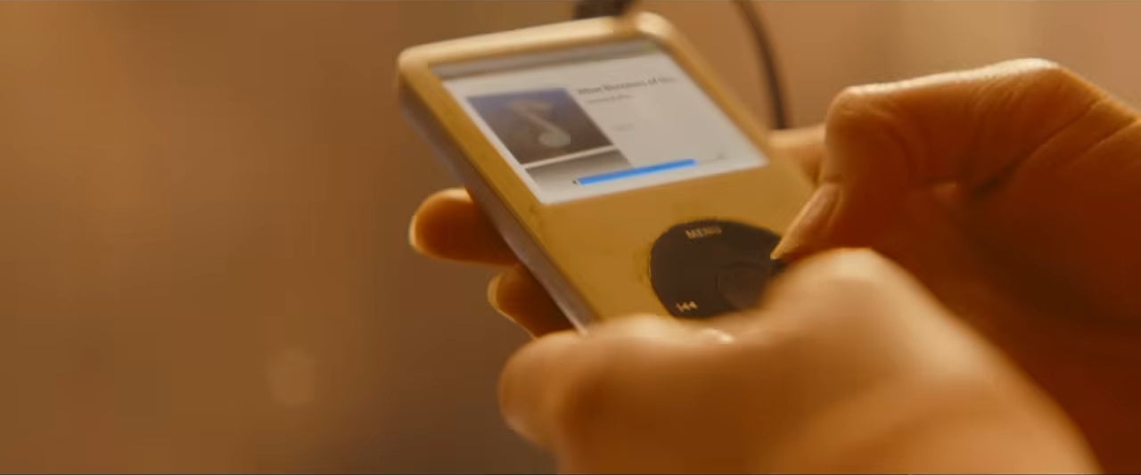Person holding an iPod, scrolling through music