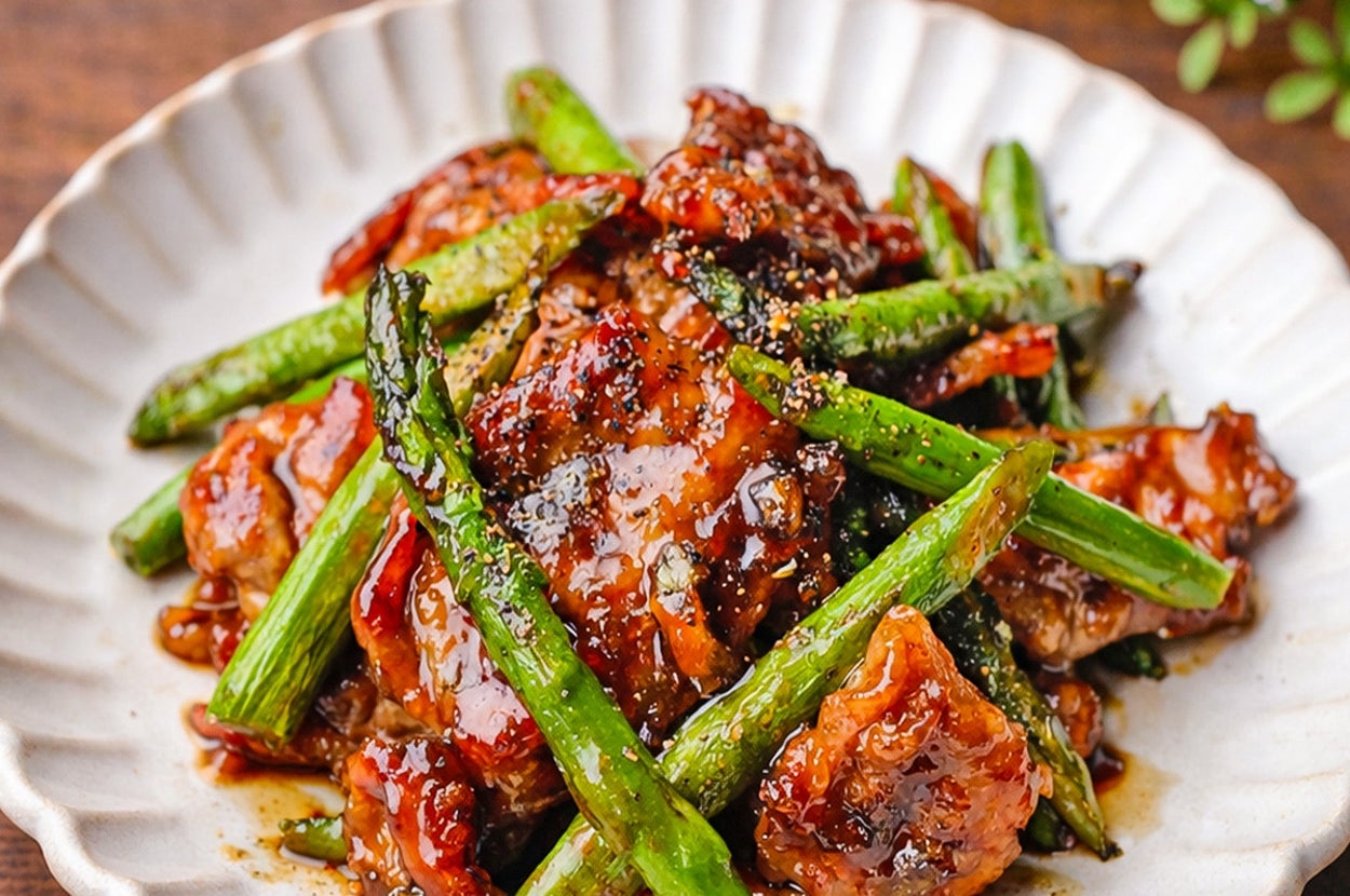 皿に盛り付けられた照り焼きビーフとアスパラガス。食欲をそそる盛り付け。
