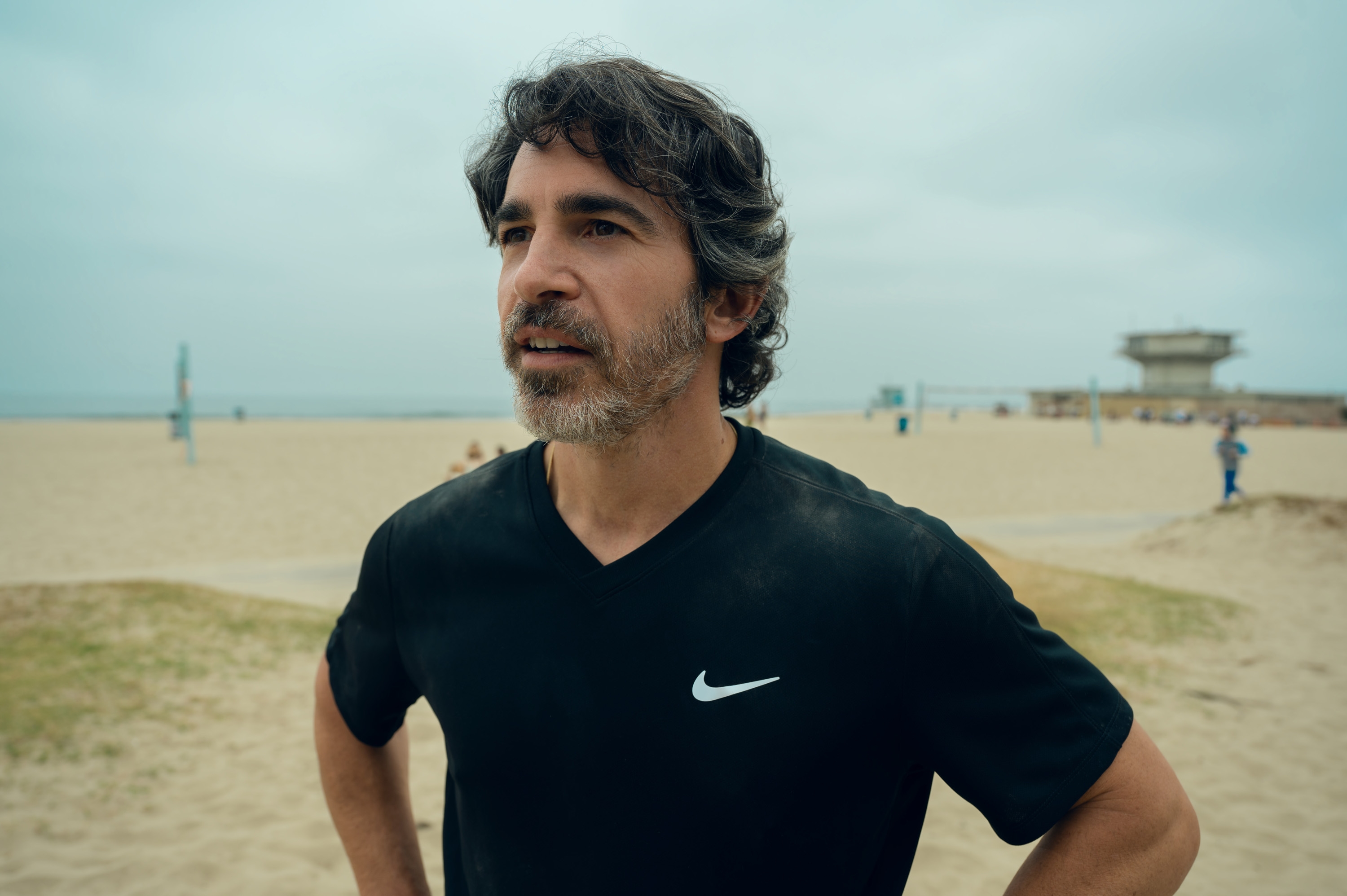 A antheral stands connected a formation with his hands connected hips, wearing a casual diversion T-shirt