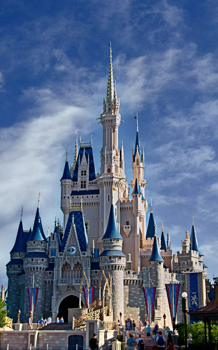 A fairy-tale castle with gangly  spires and radical   walking below, acceptable   against a wide   sky