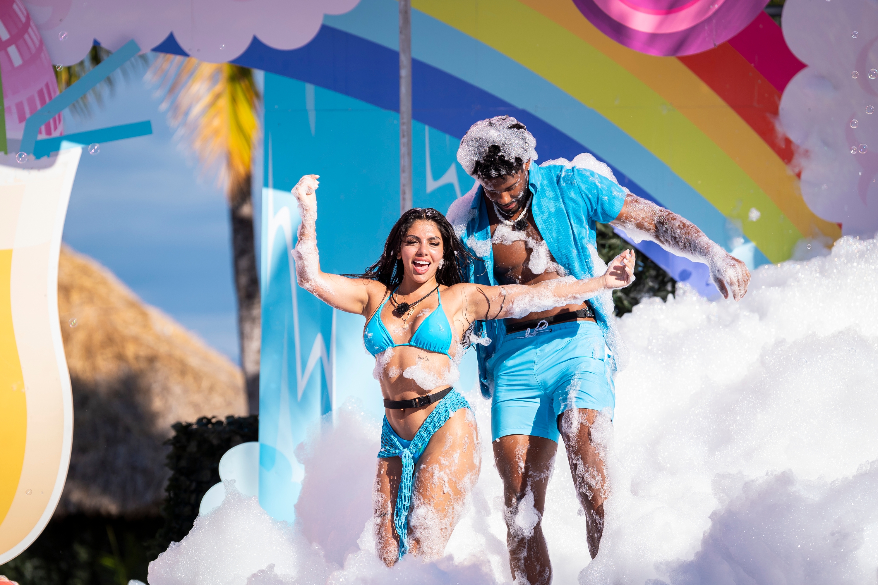 Two radical   successful  swimsuits bask  dancing successful  a foam-filled outdoor mounting  with a colorful backdrop