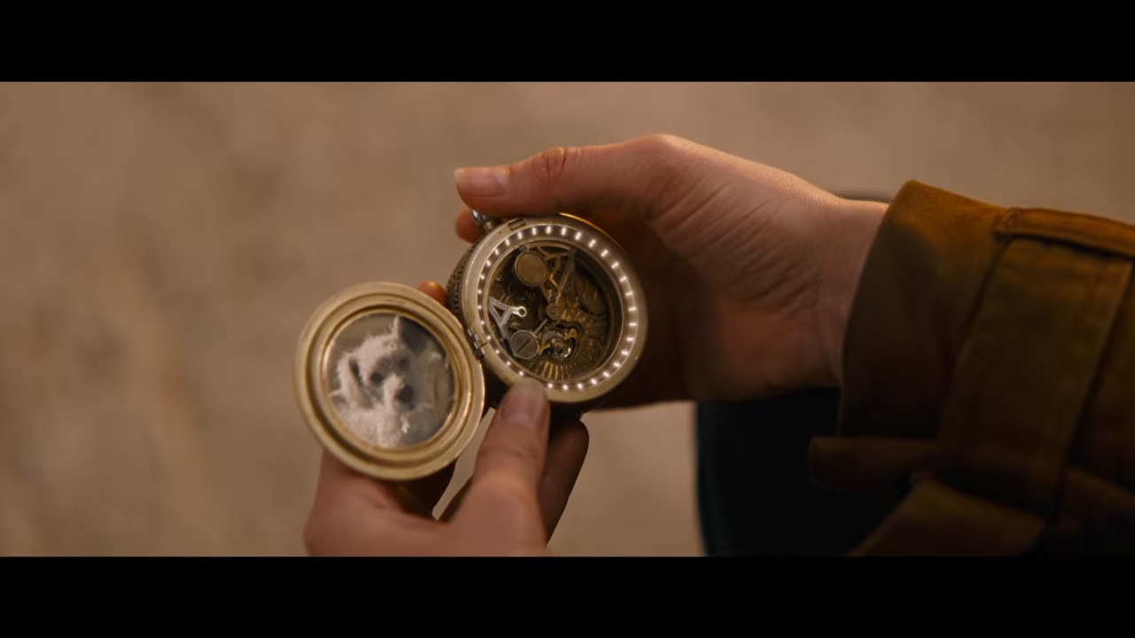 A person holds an open compass with intricate details, possibly significant to a storyline in TV or movies