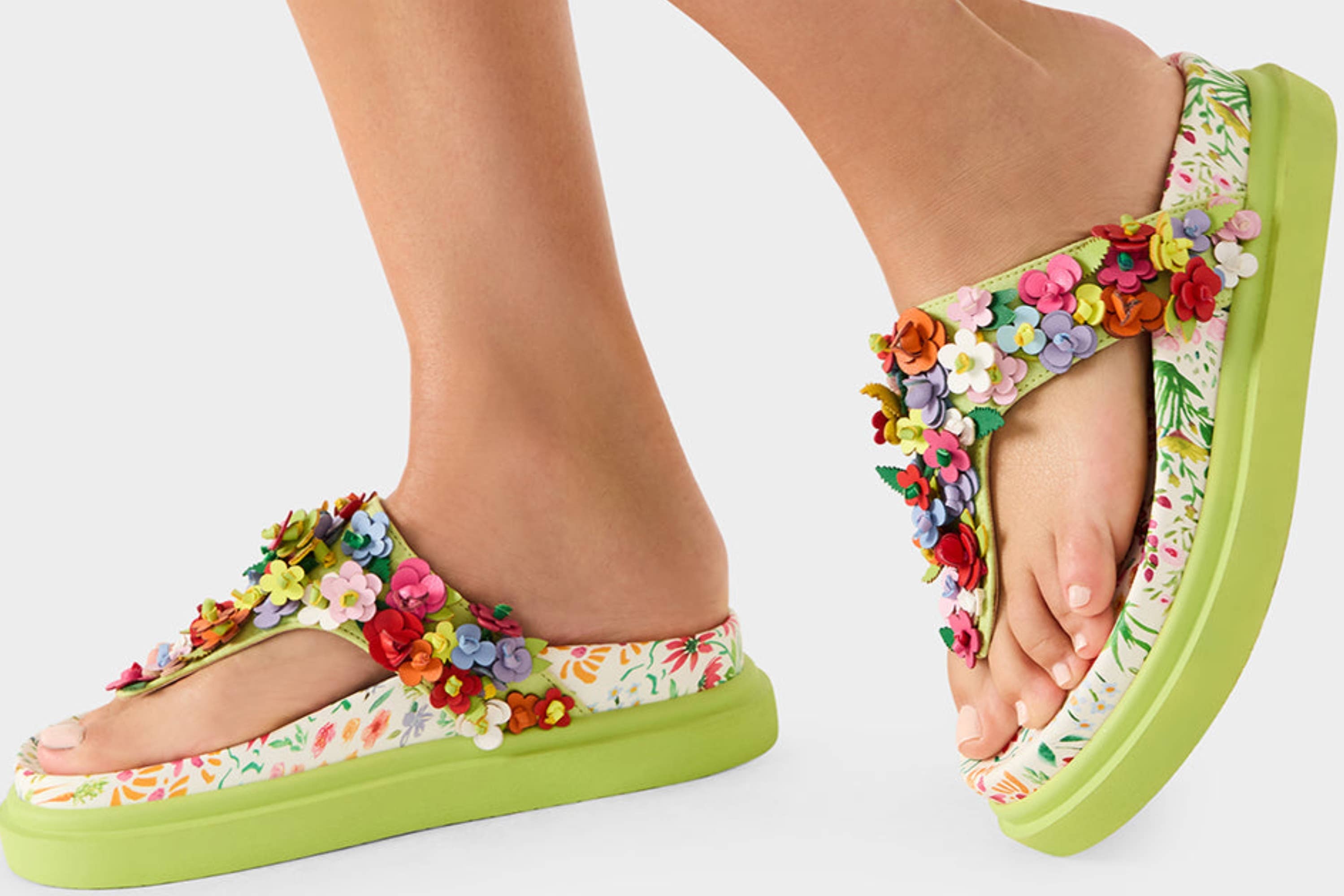 model in chunky green and multicolor floral print thong sandals with faux leather flowers covering straps