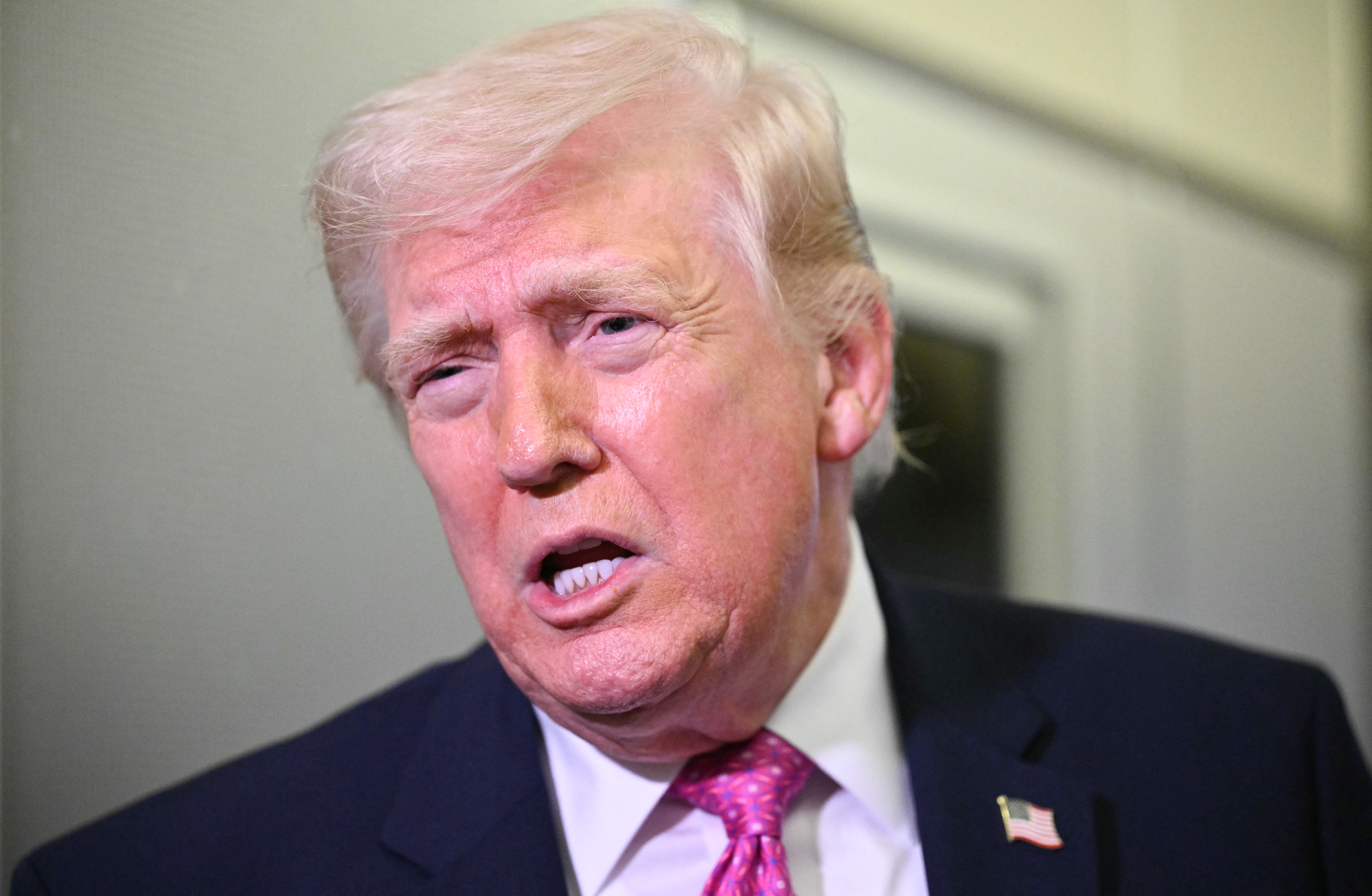 En person i dress og slips snakker, virker engasjert og uttrykksfull i samtalen