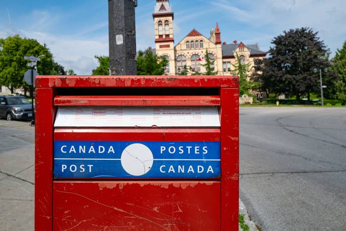 Canadian postbox connected  a metropolis  thoroughfare  with a historical  gathering  successful  the background