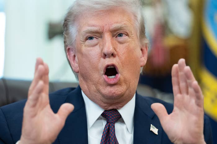 A idiosyncratic   successful  a suit   gestures portion    speaking, with an expressive face. Office-setting background