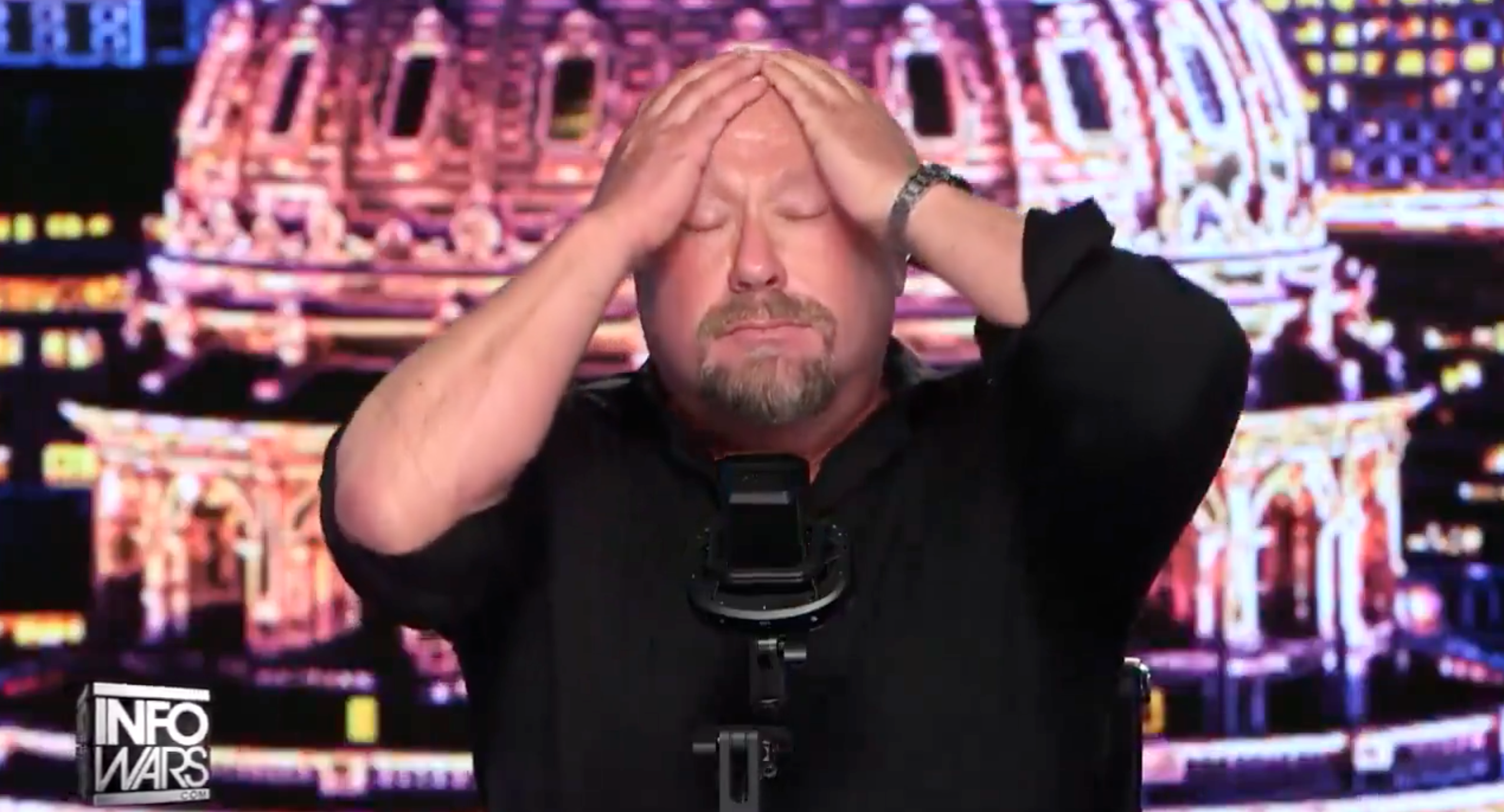 A antheral   is sitting astatine  a table  with his hands connected  his head, appearing distressed, successful  a workplace  setting