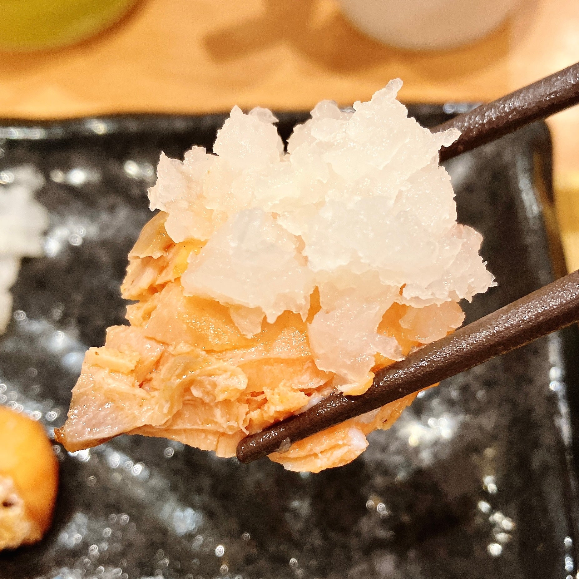 COCO'S（ココス）の「銀鮭の朝定食～鬼おろし添え～」箸でつままれた銀鮭と鬼おろしのアップ写真