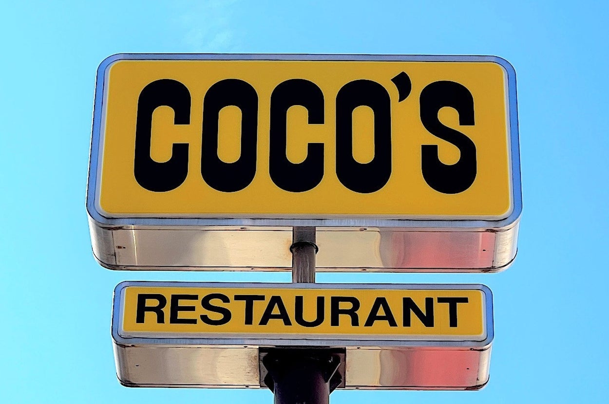 「COCO'S RESTAURANT」の看板が青空に映えているシーン。