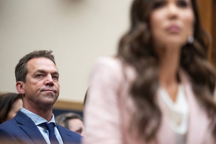 A antheral   successful  a suit   attentively listens successful  a ceremonial  setting, portion    a pistillate   successful  concern  attire is successful  the foreground