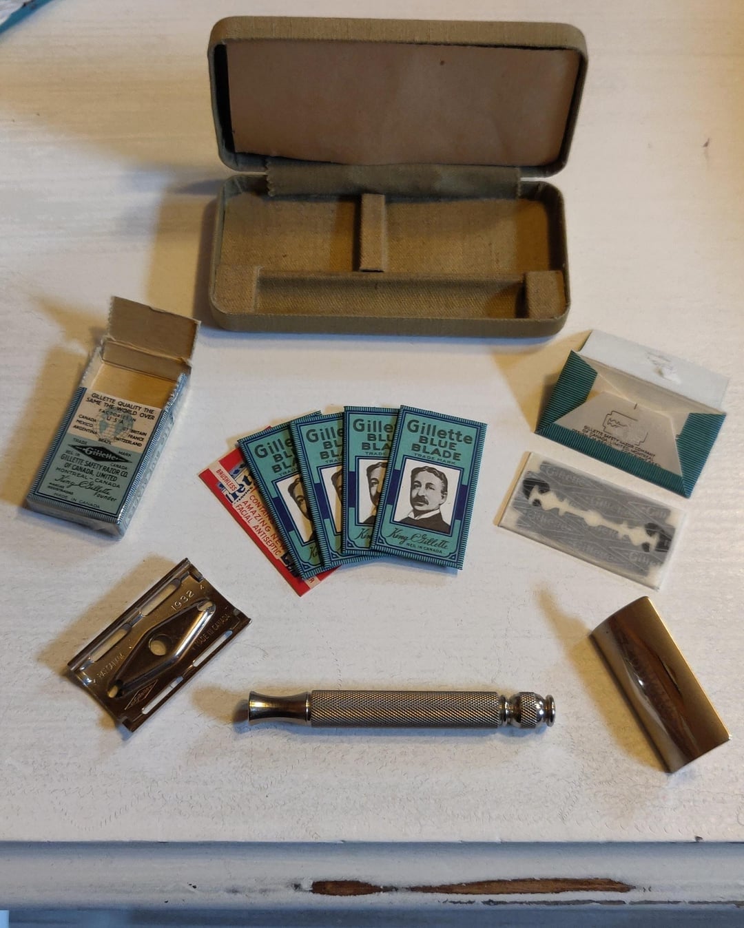 Vintage shaving kit with razor, blades, and unfastened  lawsuit  connected  a achromatic  surface