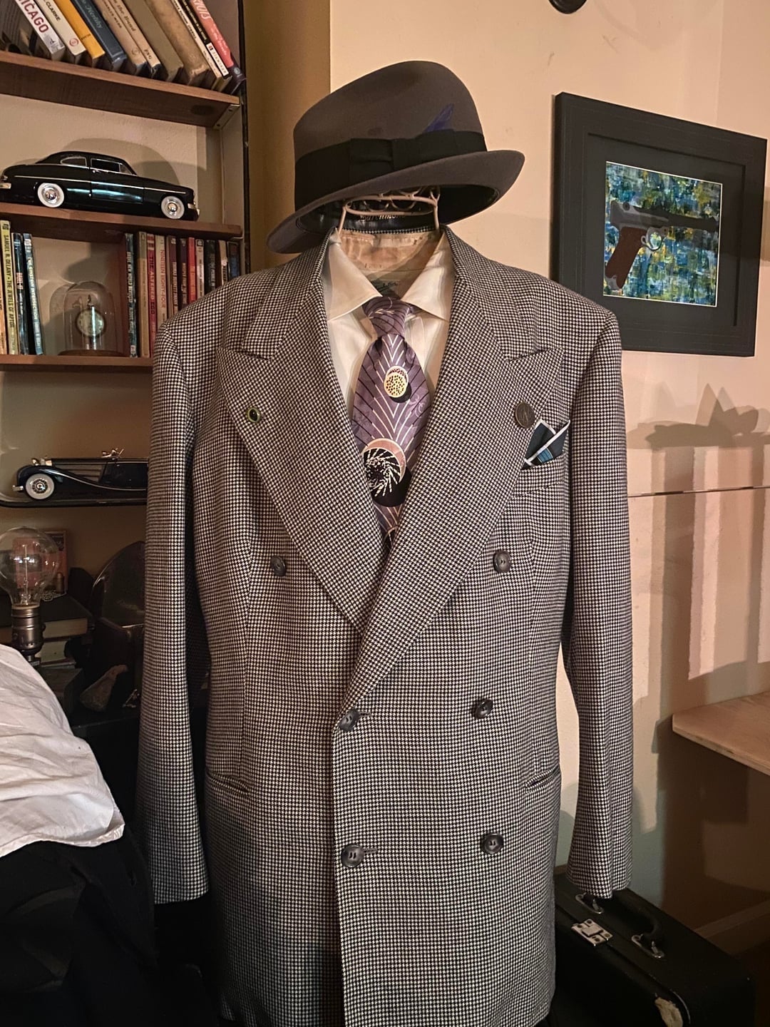 Vintage suit   with a double-breasted jacket, checkered pattern, tie, pouch  square, and fedora connected  show  successful  a country   with exemplary  cars connected  shelves