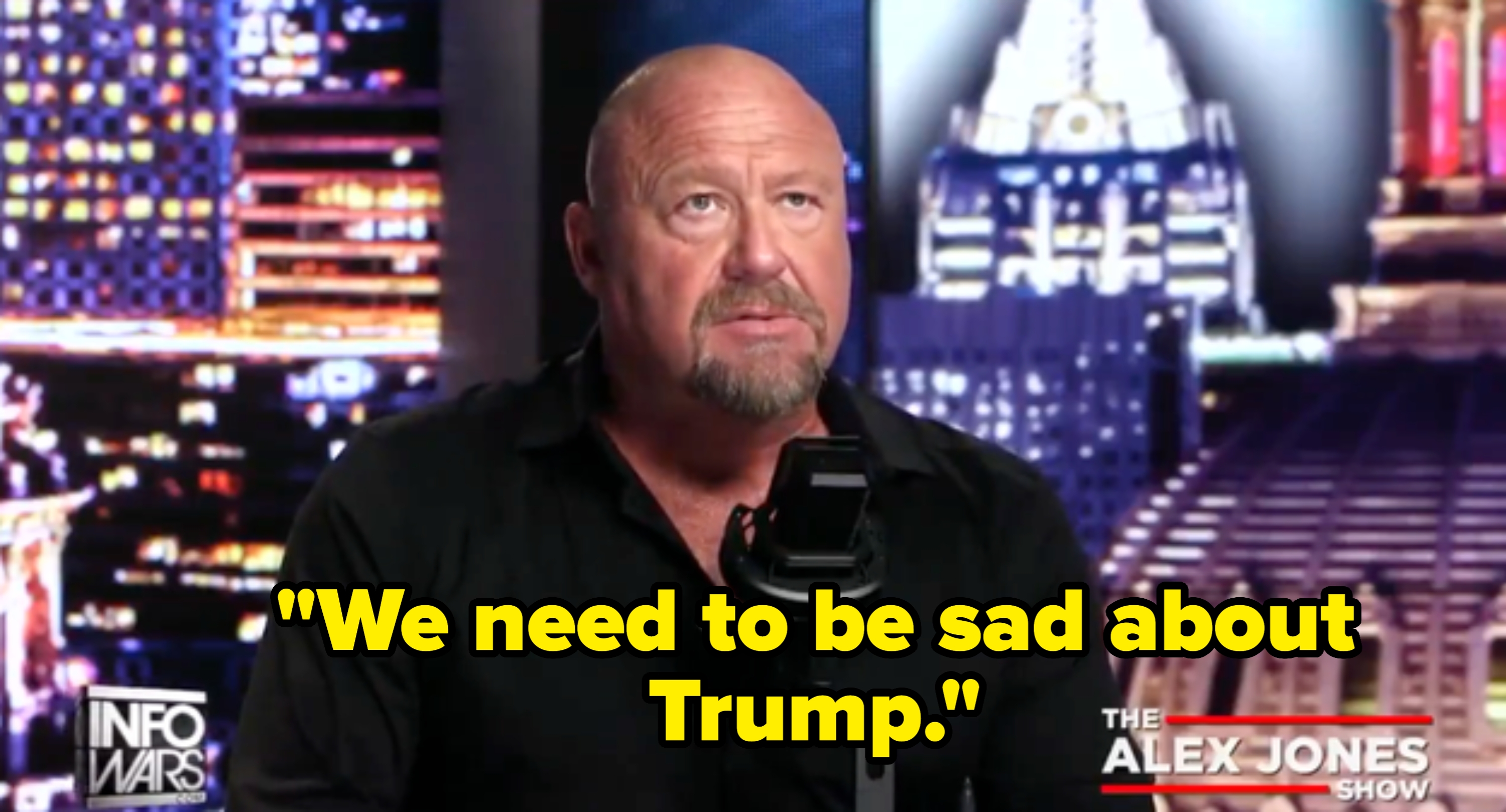 A idiosyncratic   seated astatine  a broadcasting desk, speaking into a microphone connected  a acceptable   with cityscape imagery and amusement   branding