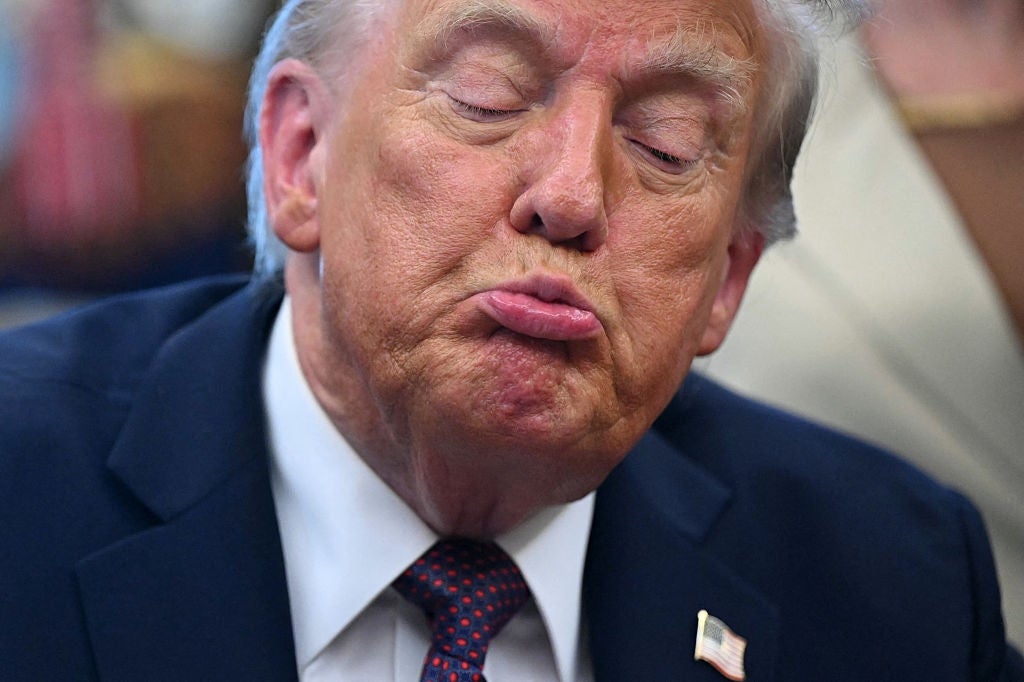 En person med lukkede øyne gir et rynket leppeuttrykk mens han har på seg en dress med en liten jakkeslagsnål