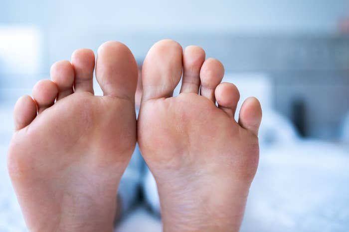 Close-up of the soles of 2  quality  feet, relaxing connected  a brushed  surface