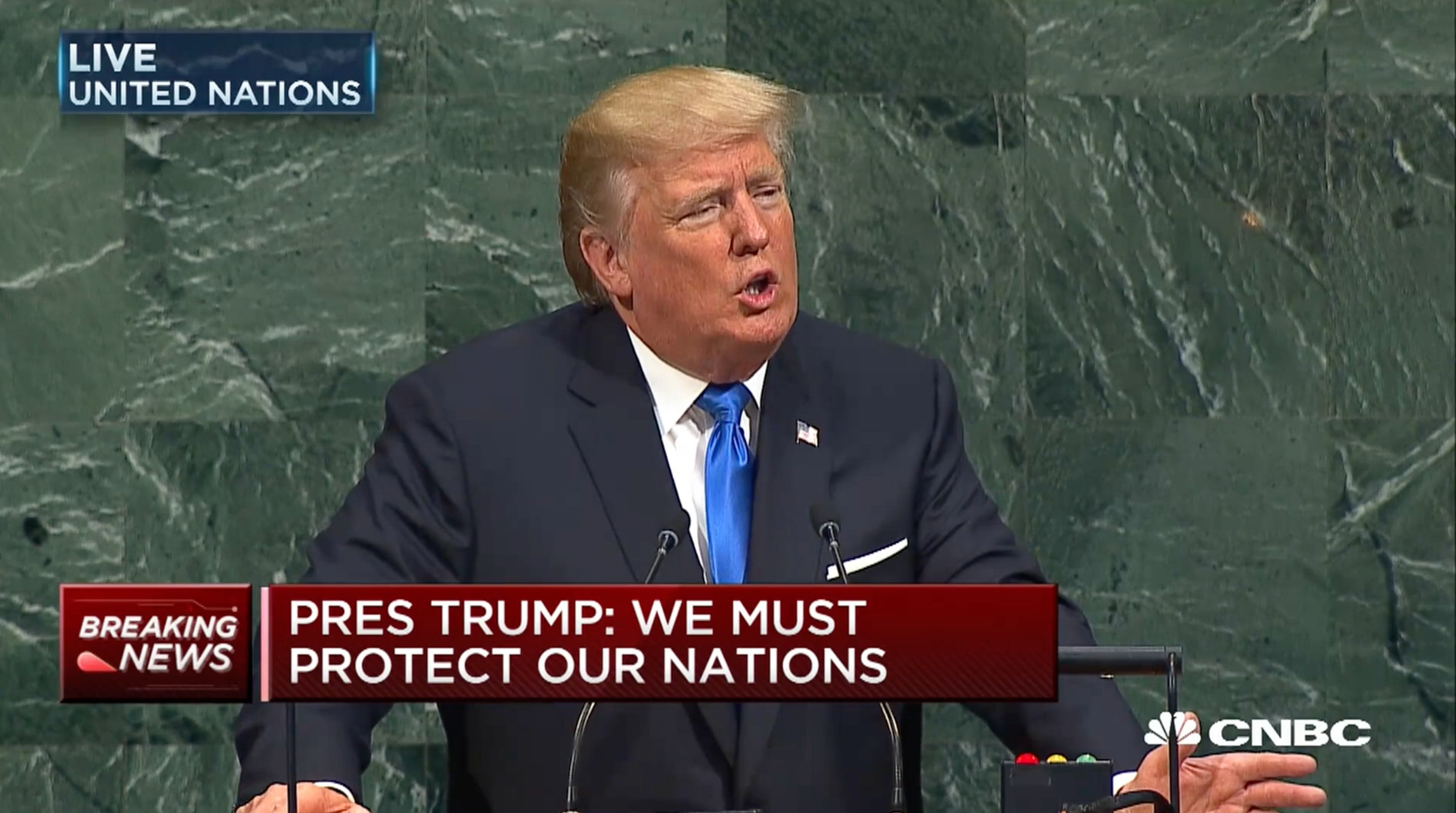 Person ved FNs podium, taler under en direktesending. Skjermtekst: "Press Trump: We must protect our nations."