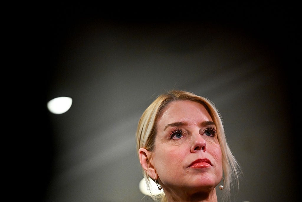 En person med langt hår ser gjennomtenkt ut, med en uskarp bakgrunn av lys