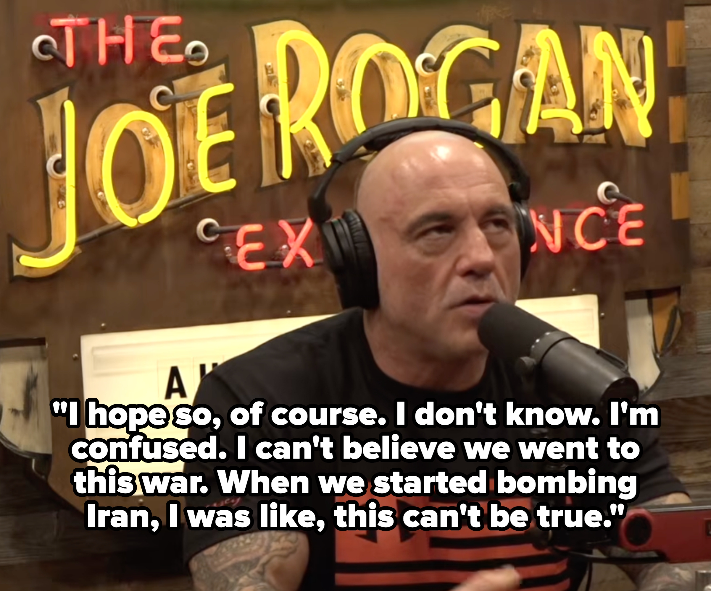 Man with headphones speaking into a microphone connected  a podcast acceptable   with "The Joe Rogan Experience" motion   successful  the background