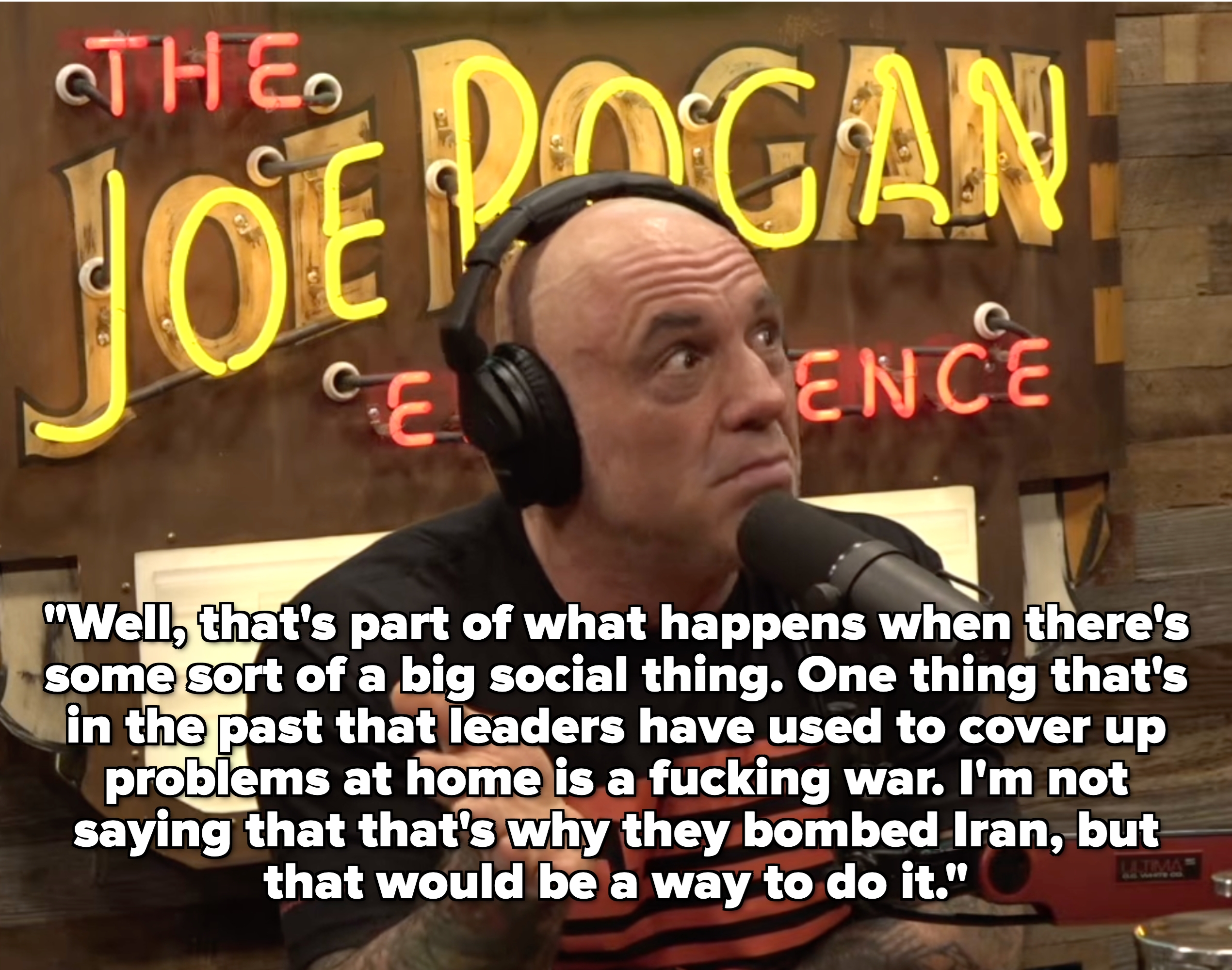 A idiosyncratic   speaking into a microphone during a podcast recording, with "The Joe Rogan Experience" disposable   successful  the background