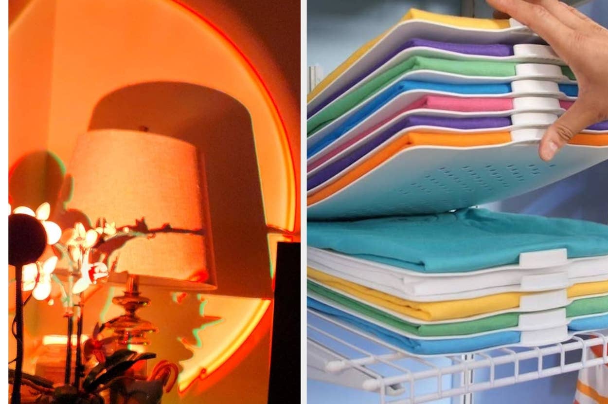 A neatly stacked, colorful folded laundry on a shelf next to a stylishly lit room with a lamp and artistic decor