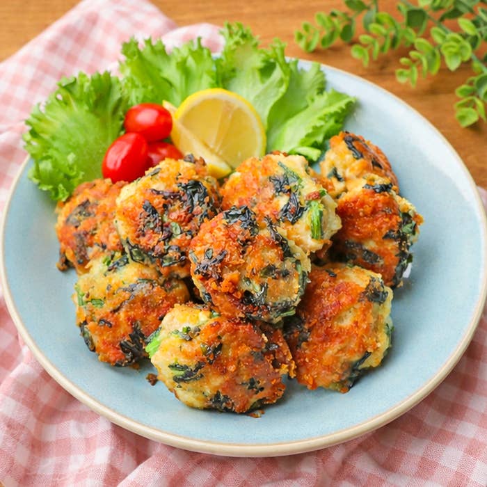 お皿に盛られた、レモンとサラダを添えた揚げボールの料理。
