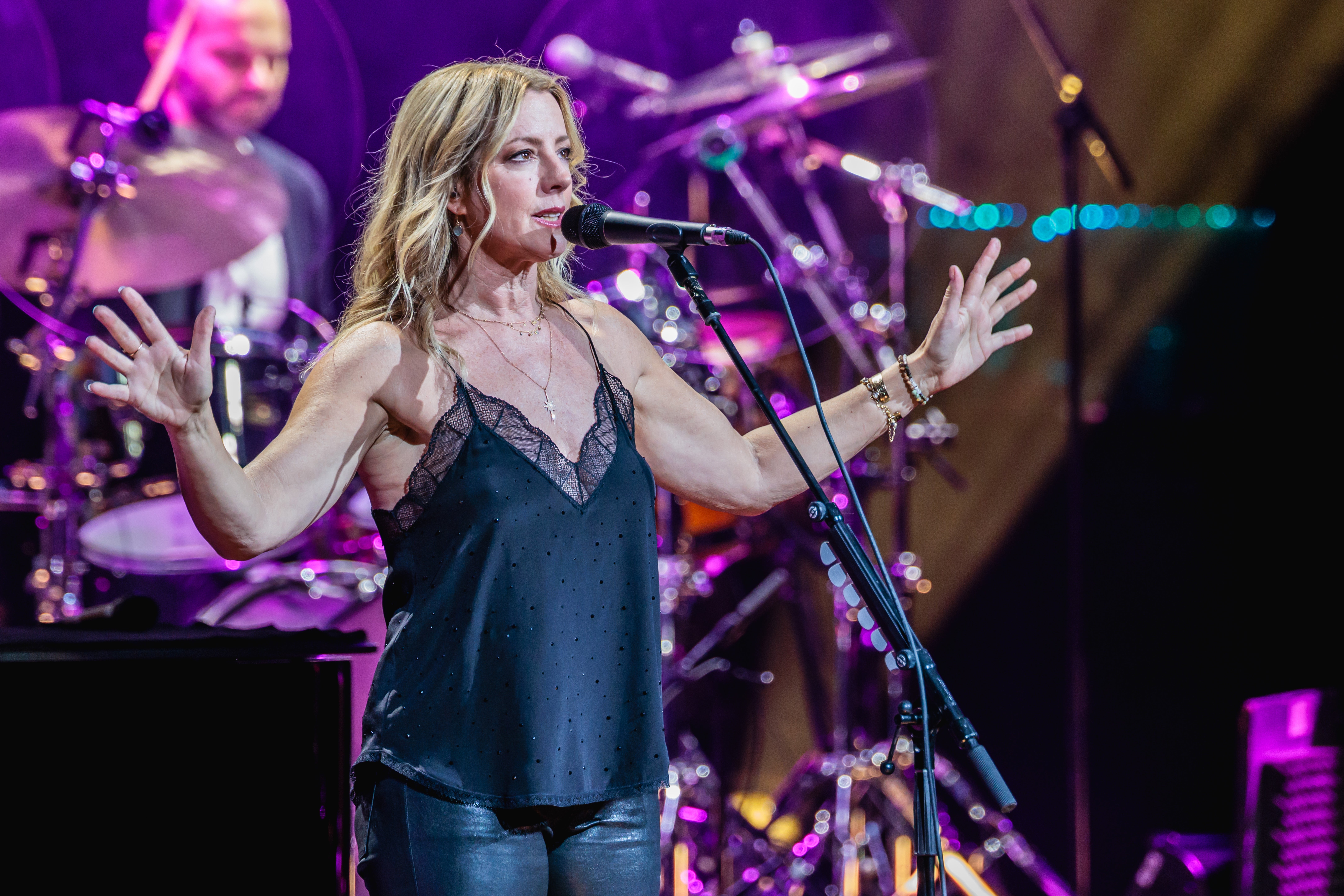 Woman performing connected  signifier    successful  a sleeveless apical  and leather pants, with a set  playing successful  the background