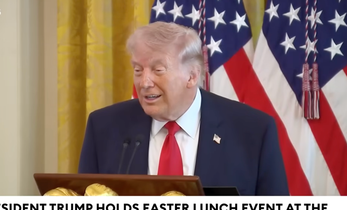 Donald Trump taler ved et podium med amerikanske flagg i bakgrunnen under et påskelunsj-arrangement i Det hvite hus