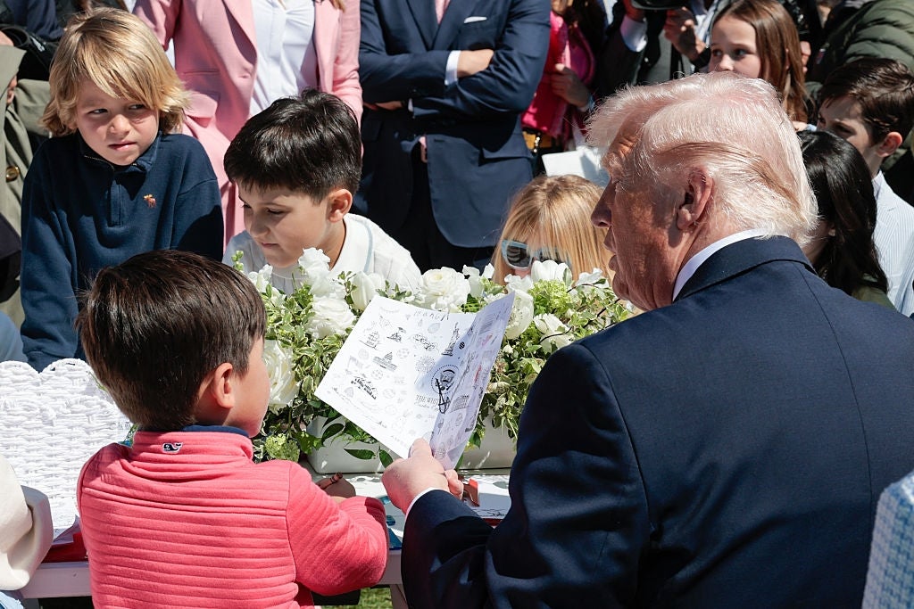 En mann som vender bort, engasjerer seg med barn rundt et bord som viser tegninger og origamiskulpturer