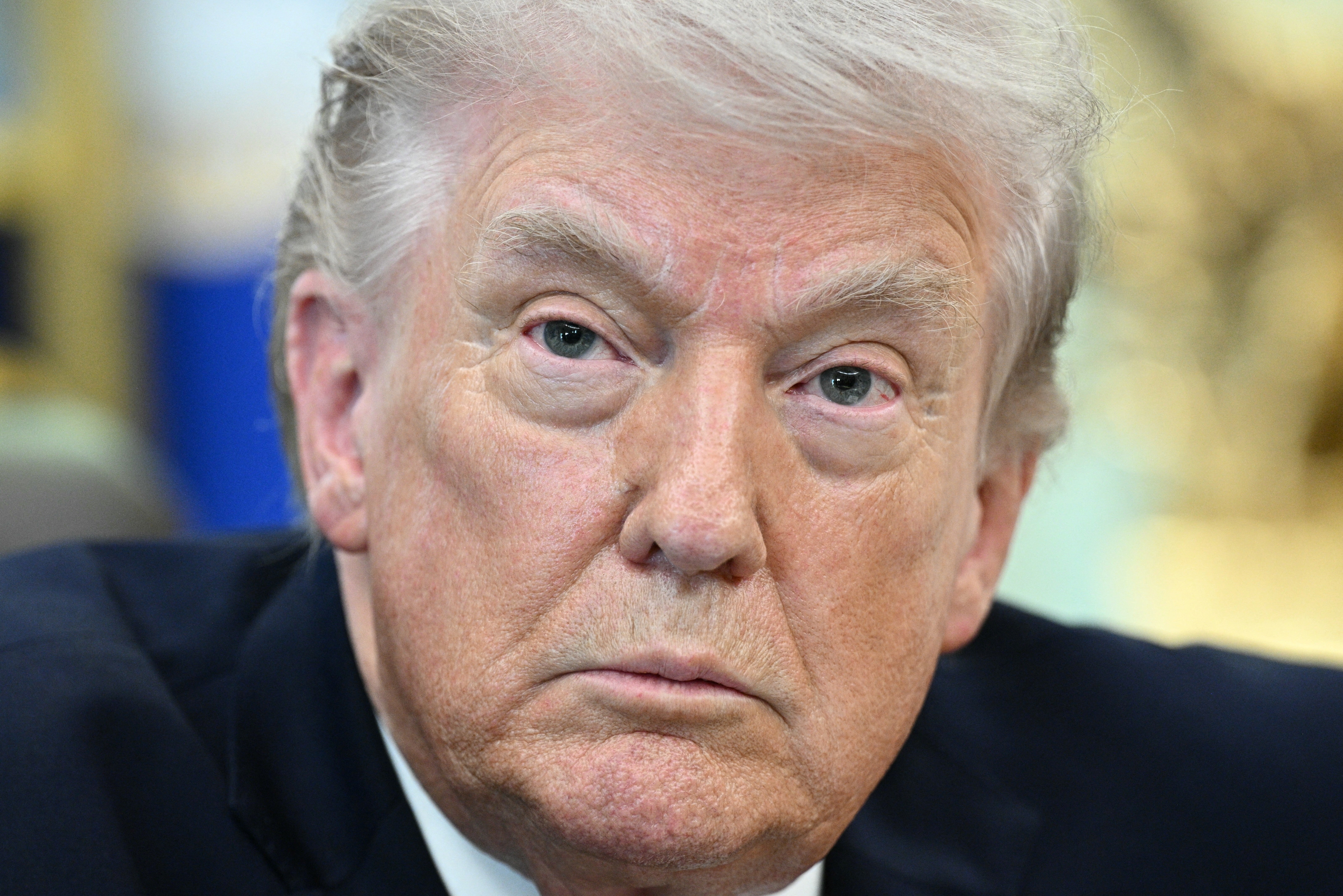 En eldre mann med et alvorlig uttrykk ser rett inn i kameraet