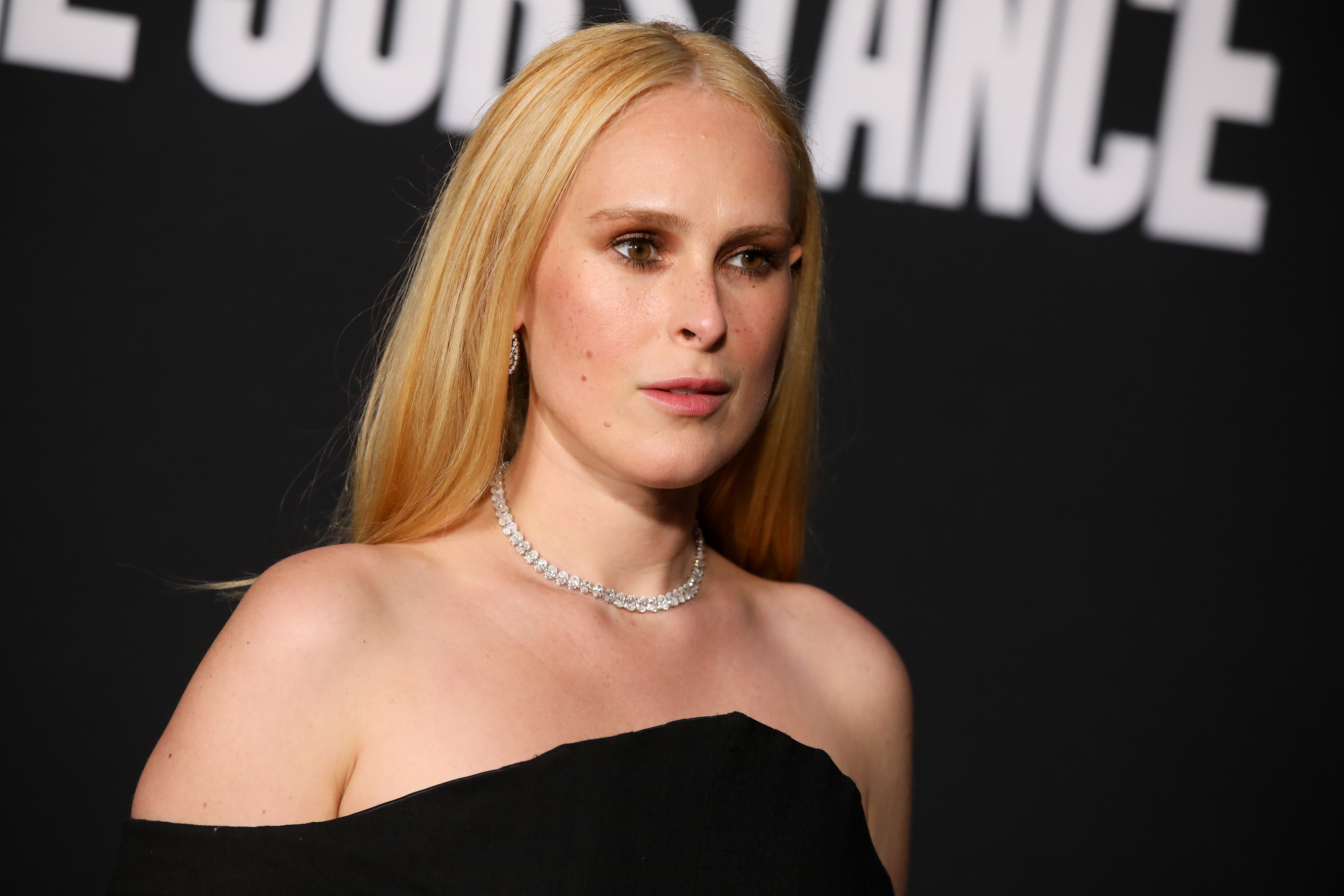 Person successful  elegant off-shoulder outfit astatine  an event, wearing a necklace