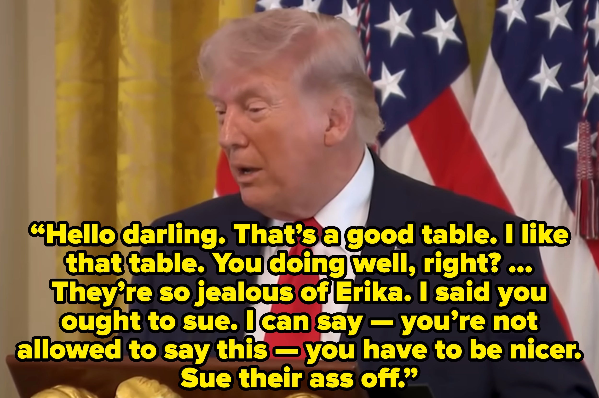 En person som snakker på et arrangement med et bakteppe av flagg, vist med et sitat om bord og råder noen til å saksøke