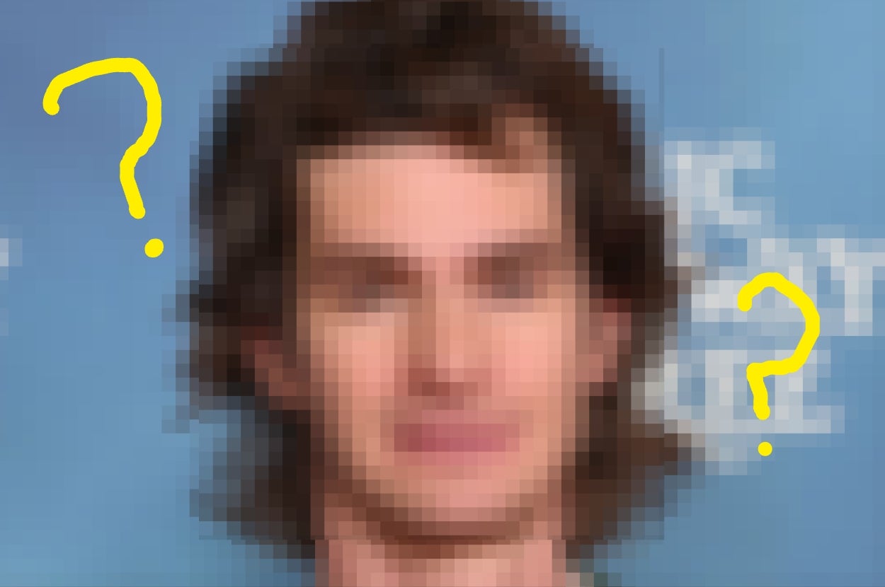 A person with medium-length hair on a press background, wearing a blazer and shirt, with question marks on the image