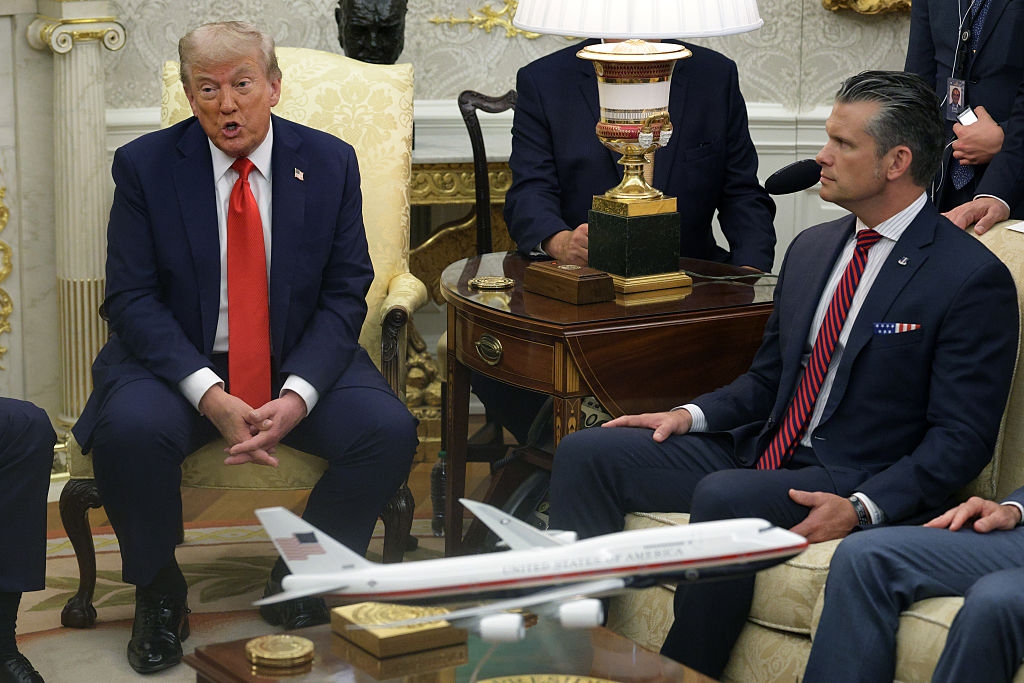 Two men successful  ceremonial  suits beryllium   successful  an ornate room, conversing. A exemplary  airplane is connected  the array  betwixt  them, suggesting a treatment  topic