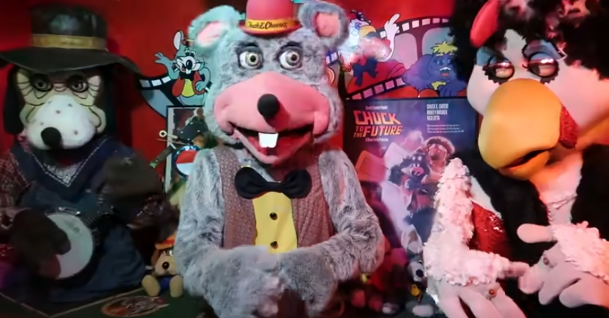 Characters from the Chuck E. Cheese animatronic set are posing successful beforehand of a film-themed backdrop