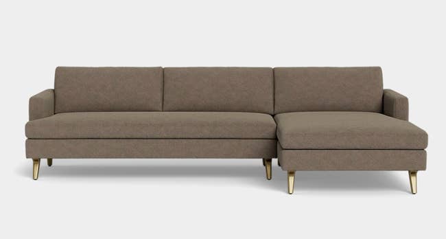 Modern sectional sofa with sleek lines and gold-tipped legs, perfect  for stylish surviving  country   settings