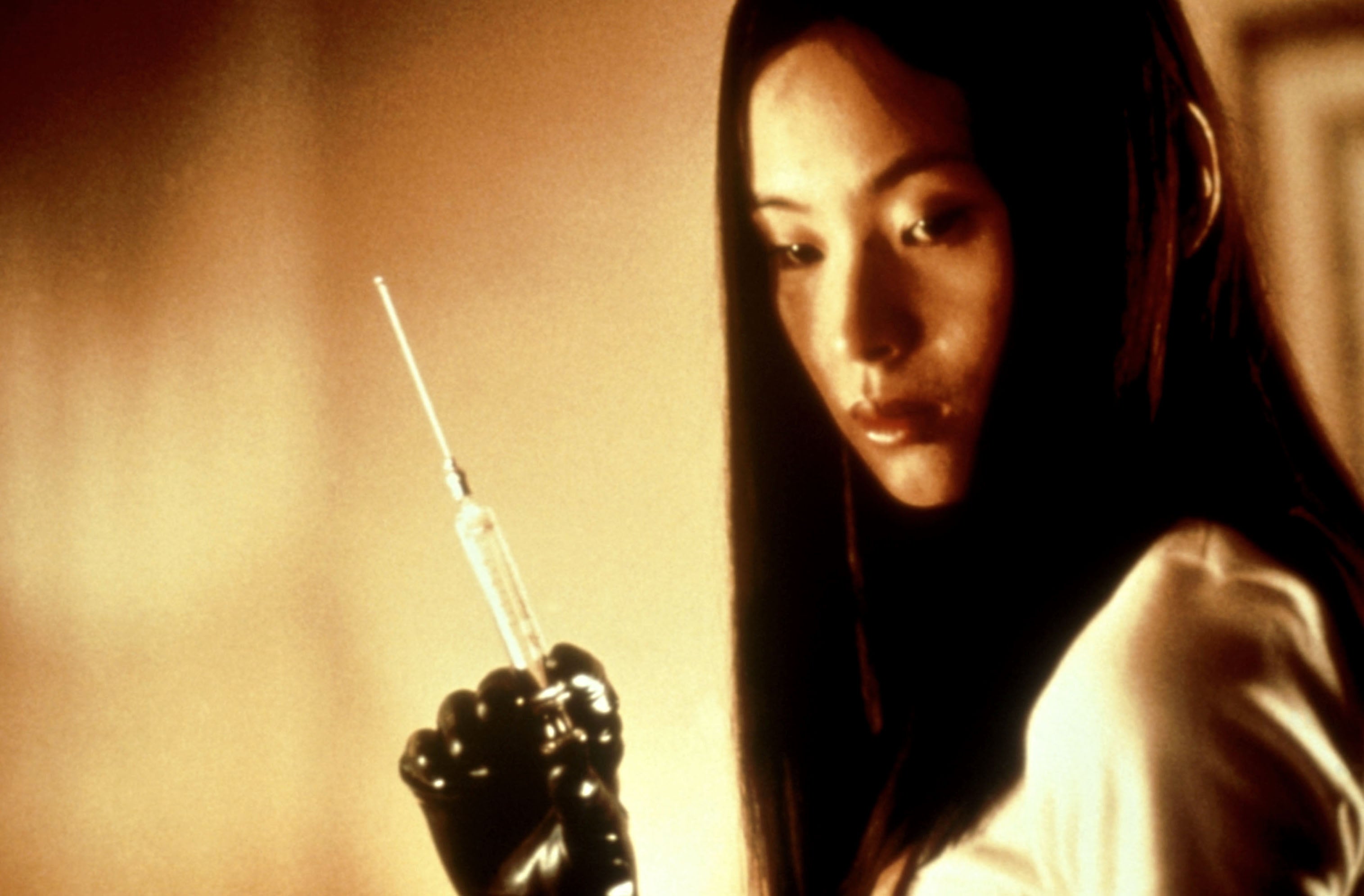 A pistillate holding a syringe with a focused expression, wearing achromatic gloves successful a melodramatic setting