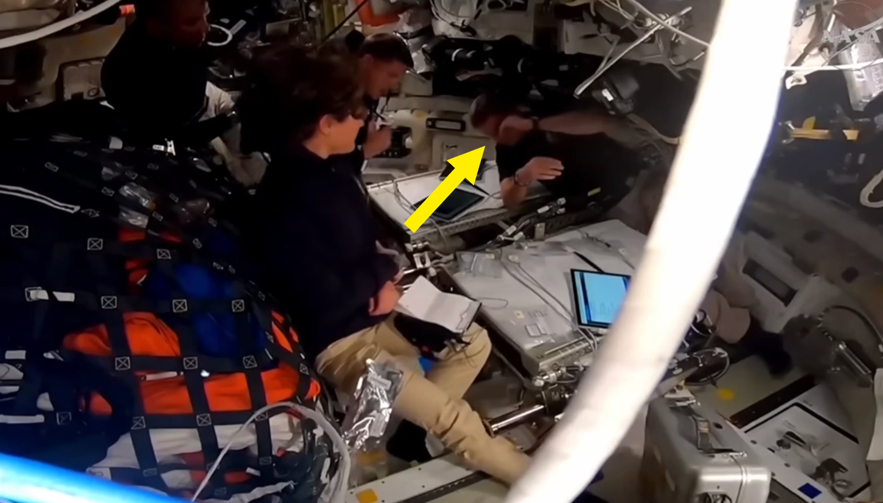 Astronauter sitter inne i et romfartøy, samhandler med skjermer og utstyr, og foreslår forberedelse eller overvåkingsaktiviteter