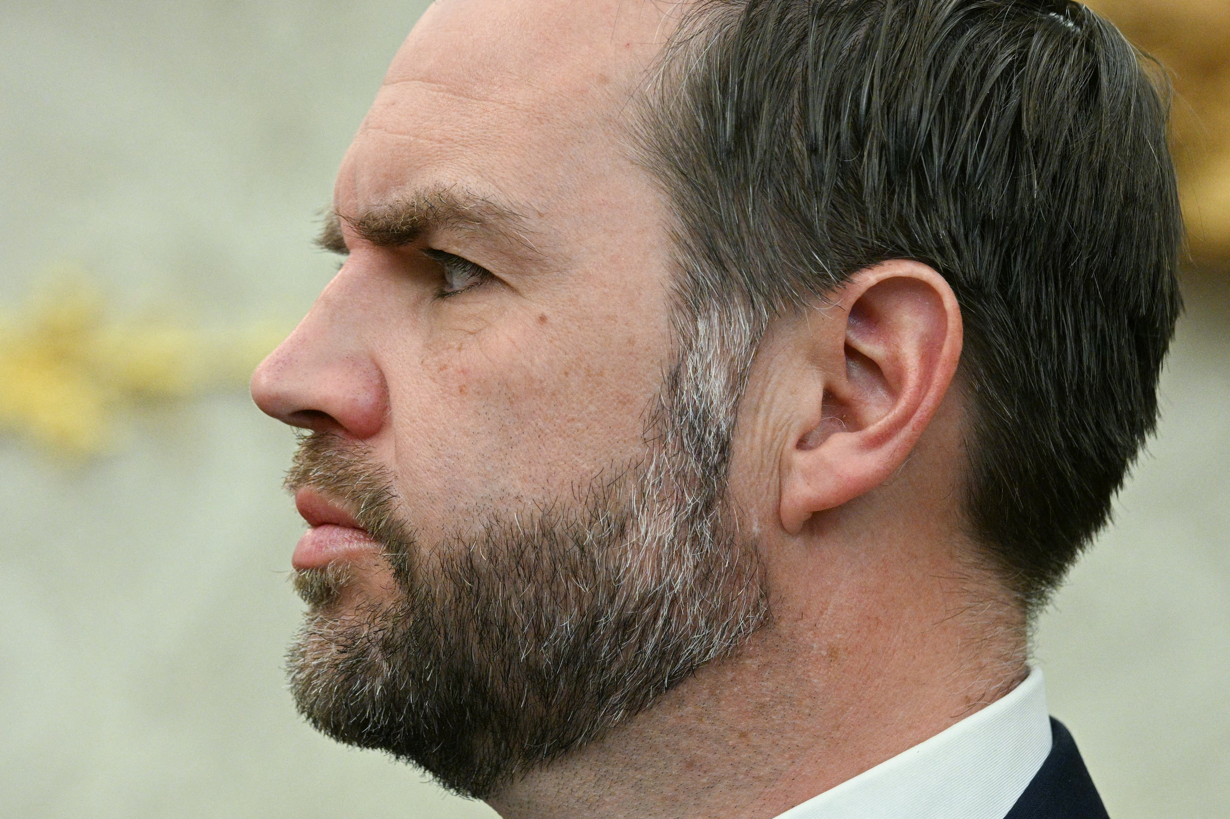 Profile of a antheral with a beard successful a suit looking thoughtful, inheritance blurred