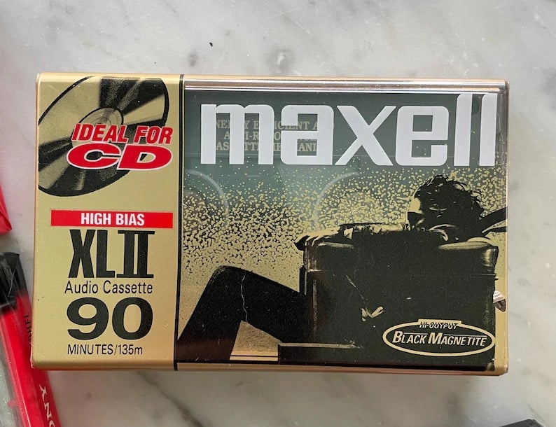 Maxell audio cassette packaging featuring classical "Blown Away Guy" illustration and substance promoting CD compatibility and precocious bias