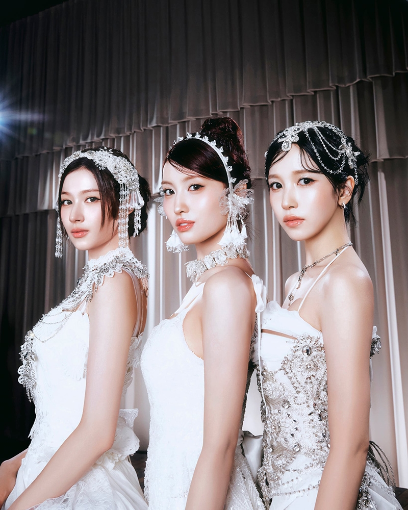 3人の女性が豪華な衣装を着て並んでポーズをとっている。