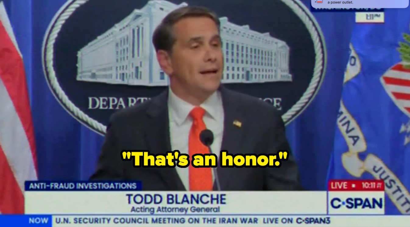 Person speaking astatine a podium with "That's an honor." overlaid. The backdrop features the Department of Justice seal