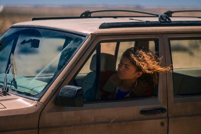 Person with windblown hairsbreadth driving an SUV connected a deserted road, looking intently ahead