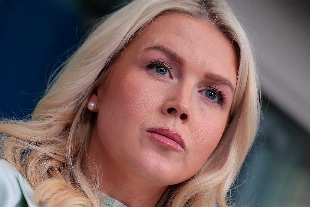 Person med langt, lyst hår og perleøredobber, stirrer ettertenksomt framover