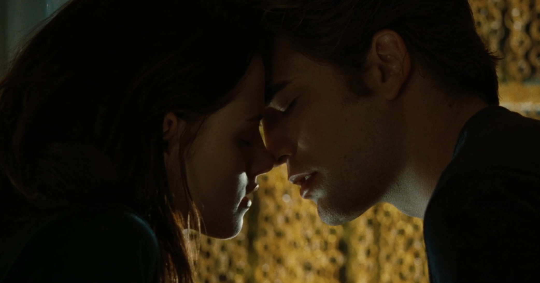 To personer lener seg tett inn med pannen i kontakt, øynene forsiktig lukket, noe som skaper et intimt og ømt øyeblikk