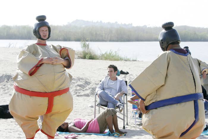 Two radical   successful  sumo costumes look   each   different   connected  a beach, with a seated idiosyncratic   watching, depicting a playful country   of leisure and relaxation